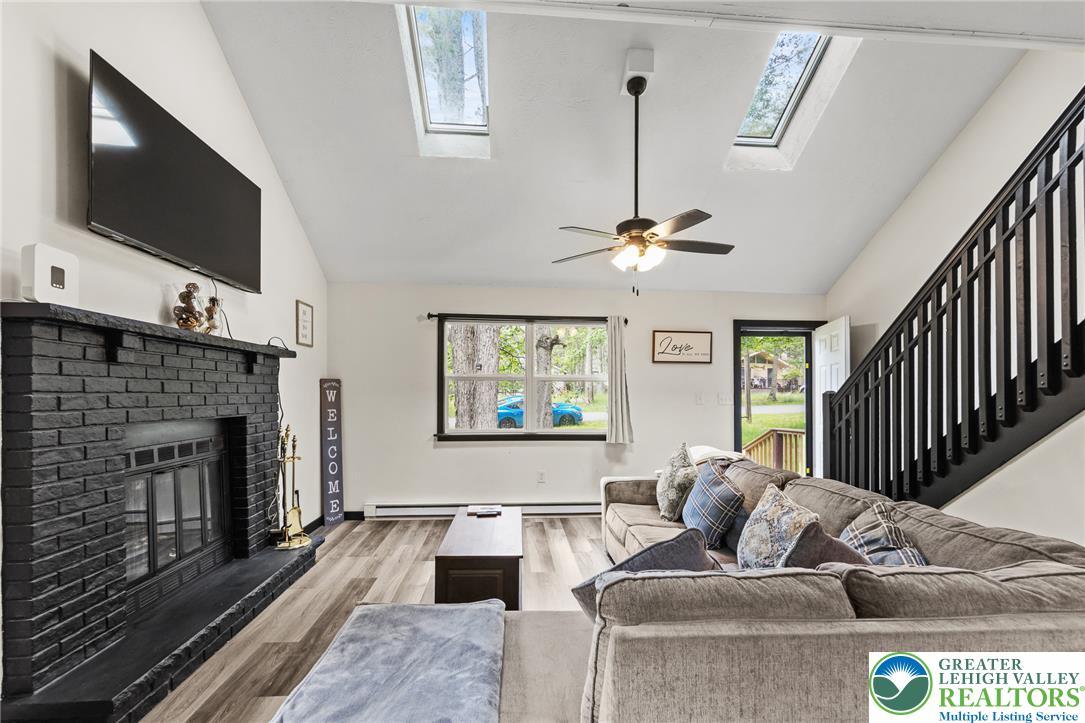 Image 4: A naturally illuminated living area featuring vaul