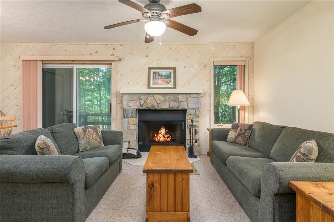 Image 2: A welcoming living area featuring a stone fireplac