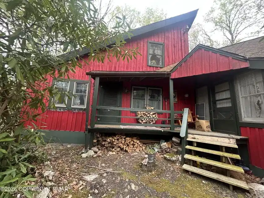 Image 1: A vibrant red siding enhances the rustic charm of