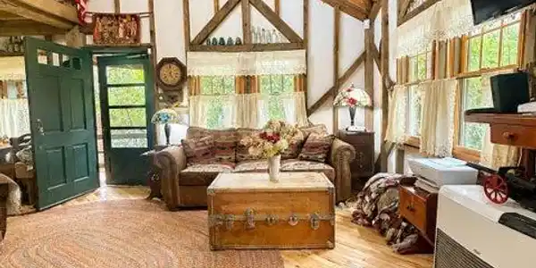 Image 3: A spacious living room with vaulted wood ceilings