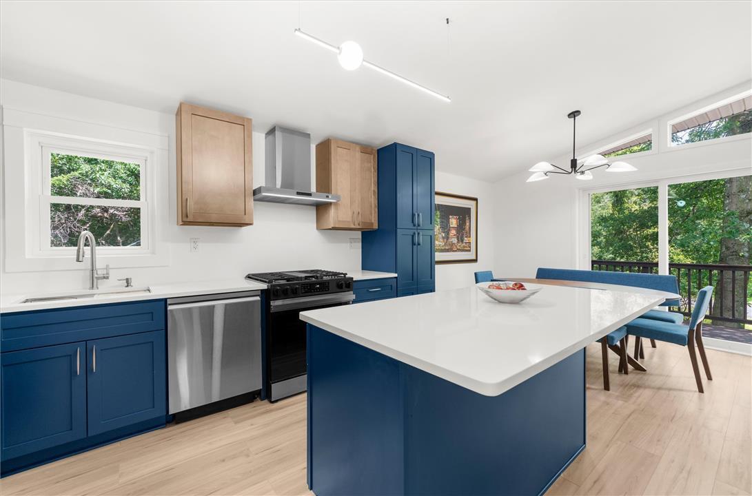 Image 3: A contemporary kitchen/dining room open to deck.
