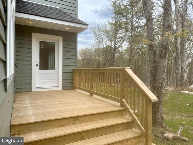 Image 4: A private wood deck extends into a peaceful wooded