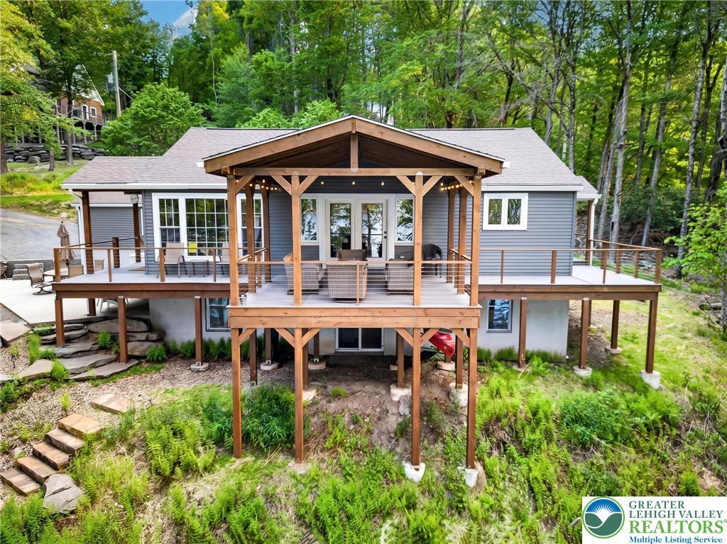 Image 4: Perched among verdant trees, this home features mu