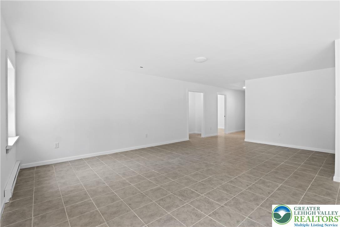 Image 4: A spacious, naturally illuminated room featuring d