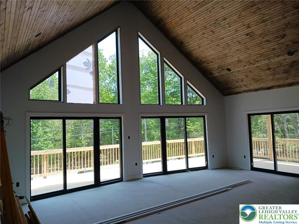 Image 4: An airy great room with vaulted ceilings and walls