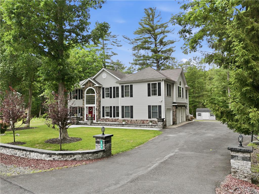 Image 3: A grand two-story residence with a stone facade an