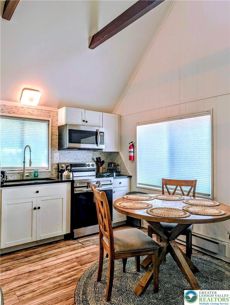 Image 4: A well-appointed eat-in kitchen with vaulted ceili