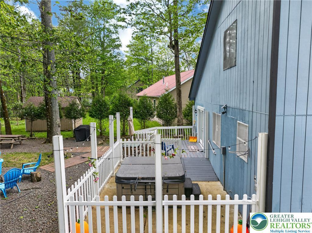 Image 4: Relax in the hot tub on the spacious deck, surroun