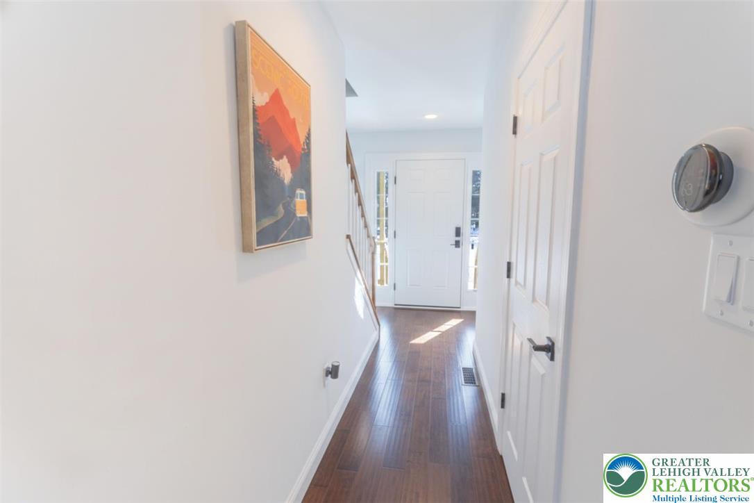 Image 3: A welcoming entryway features rich hardwood floori