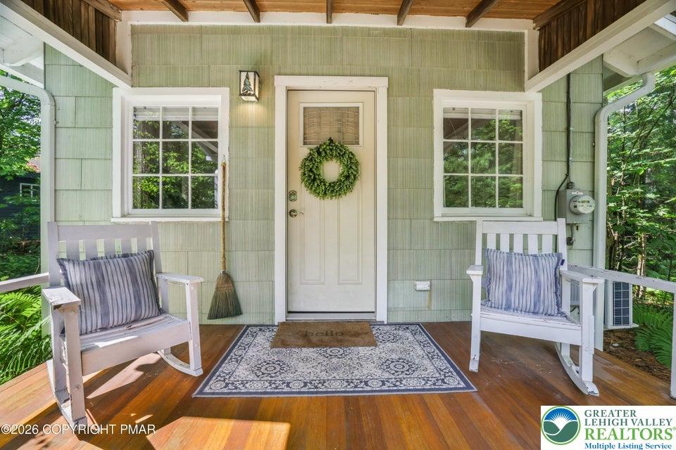Image 1: A welcoming front porch features vibrant wood floo