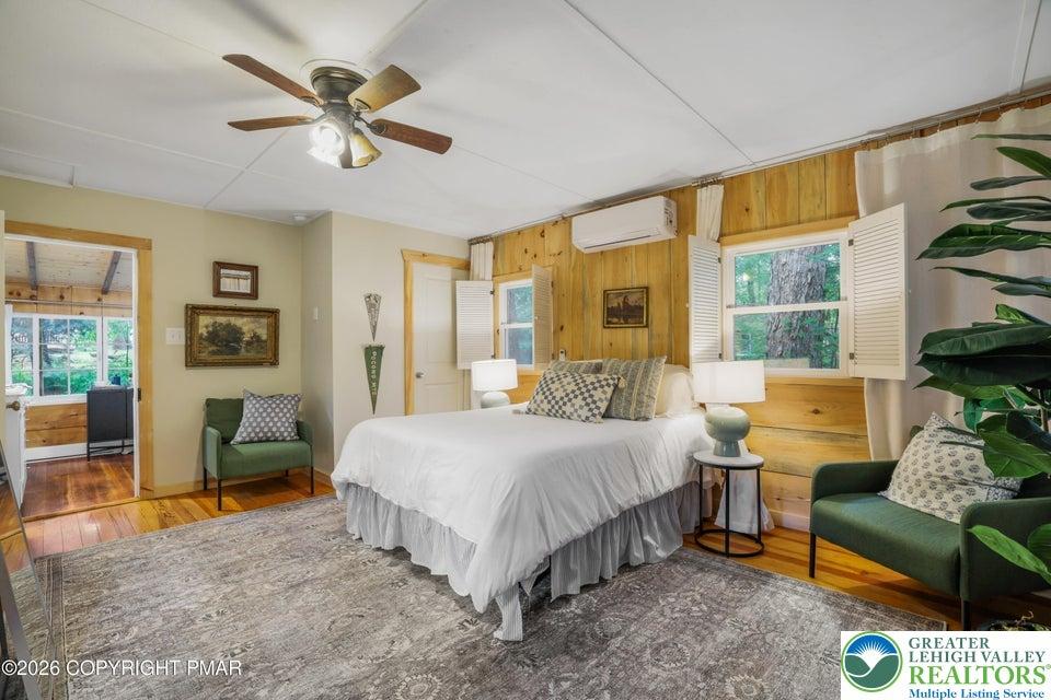 Image 2: Comfortable bedroom with warm wood paneling and ou