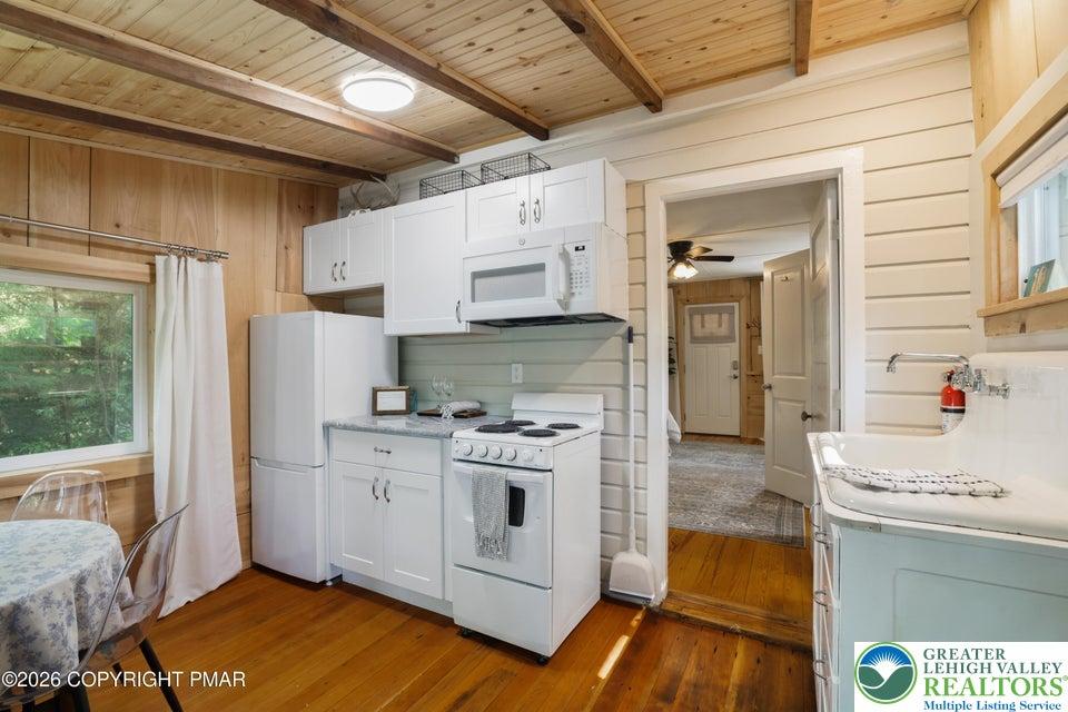 Image 3: A well-equipped kitchen features wooden flooring,