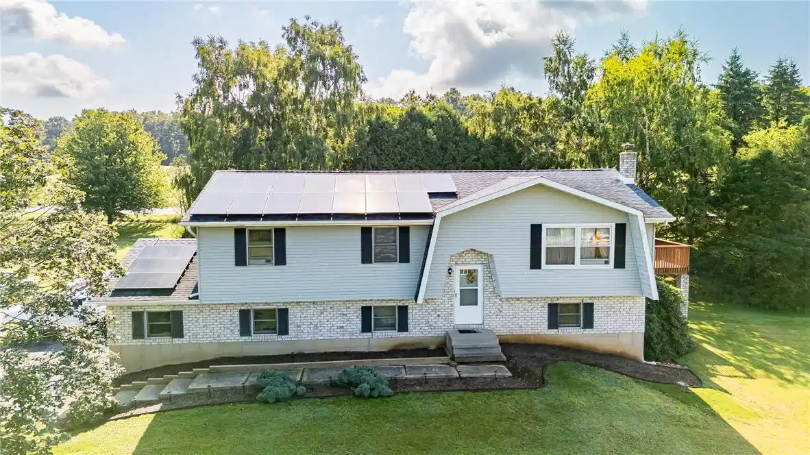 Image 1: A well-maintained home on a green hillside feature