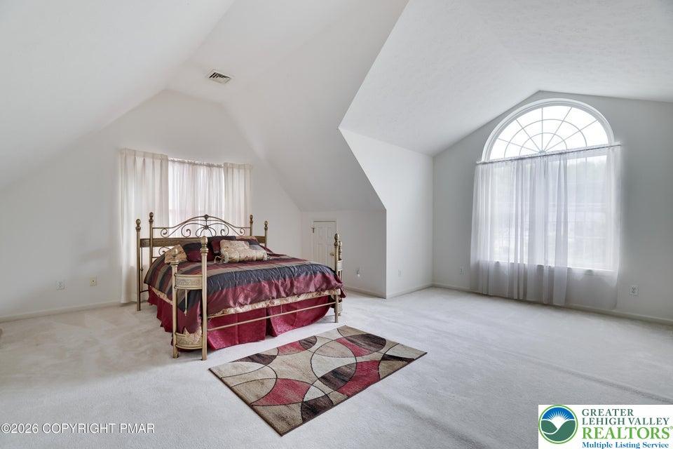 Image 4: An inviting sleeping space with sloped ceilings an