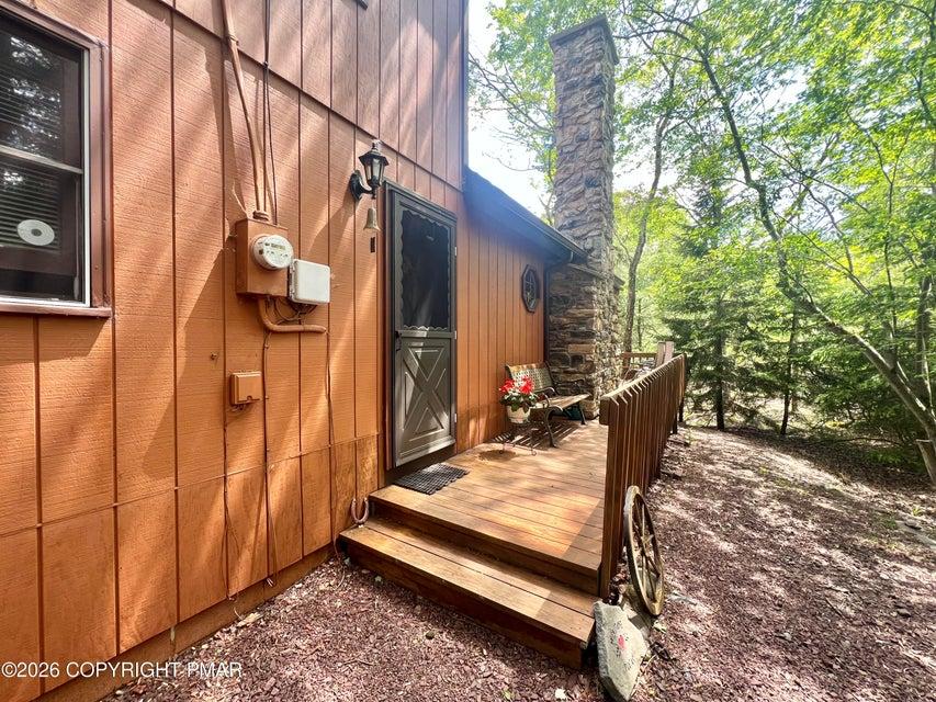 Image 2: A charming wood-sided residence boasts a stone chi