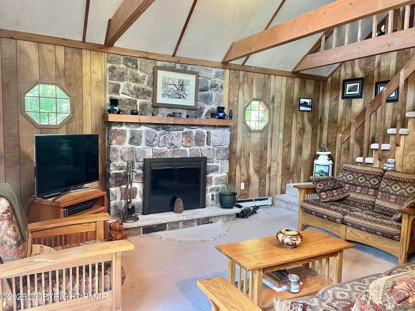 Image 4: A spacious living area showcasing a grand stone fi