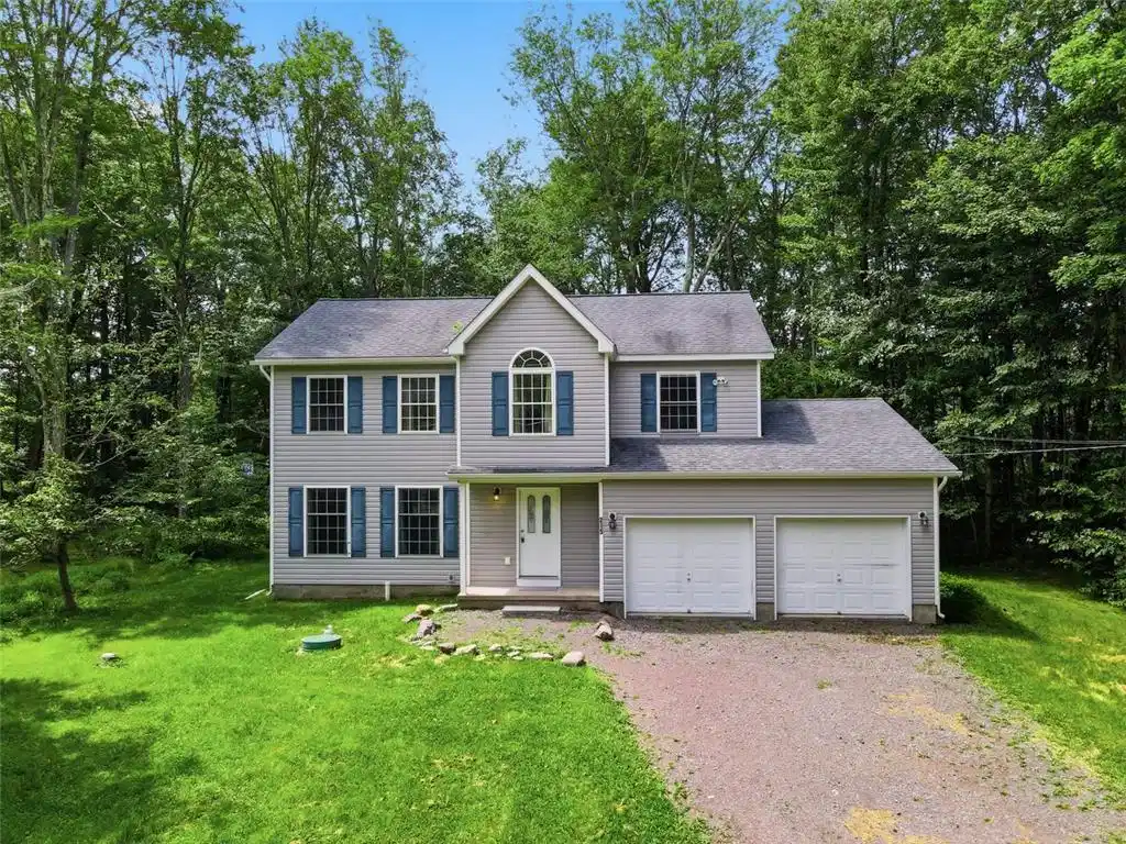 Image 1: A classic two-story home, nestled among a lush tre