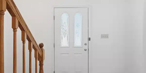 Image 3: A welcoming front entry features a crisp white doo