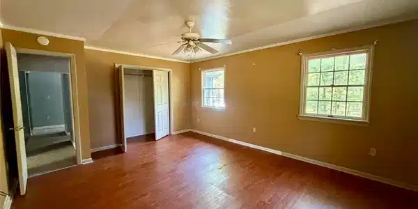 Image 3: Well-lit interior featuring polished wood flooring