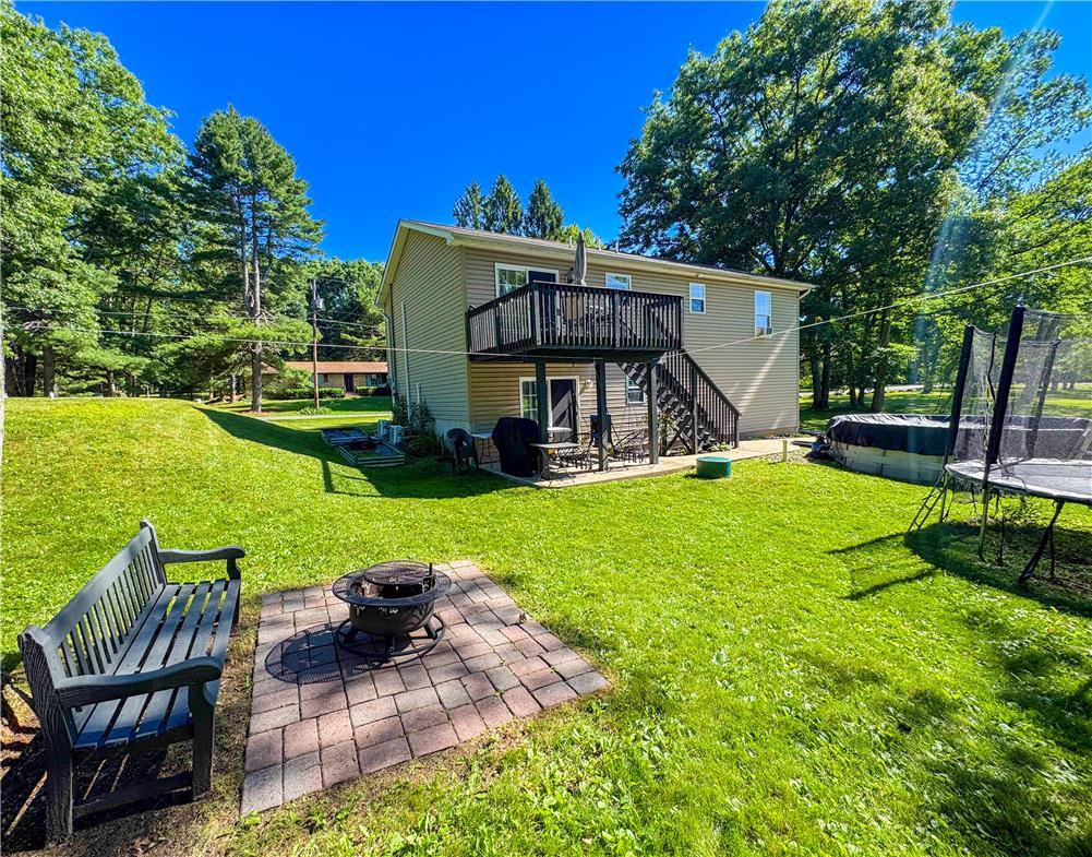 Image 4: A spacious backyard retreat features a fire pit, g