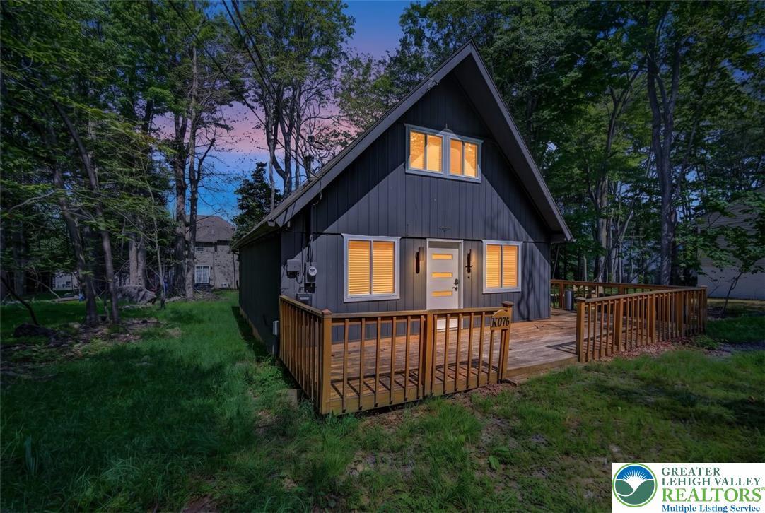 Image 4: Front Dusk View. A-frame retreat nestled amongst m