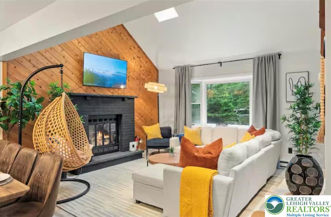 Image 2: A striking fireplace with a wooden accent wall anc