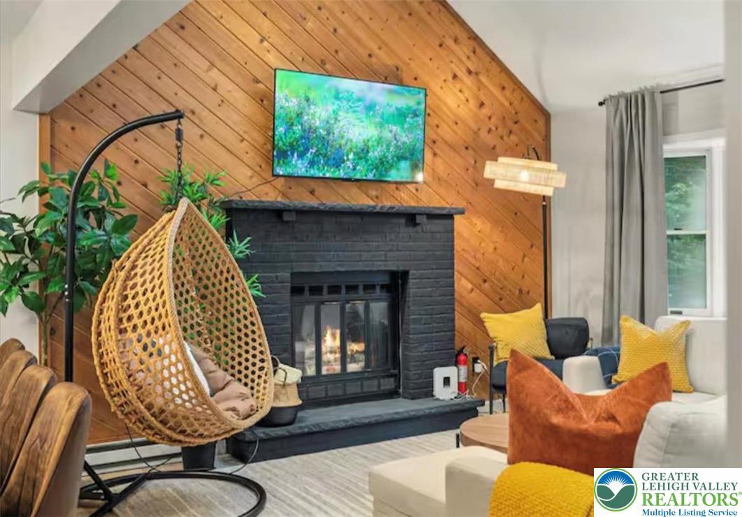 Image 3: A striking black brick fireplace anchors a living