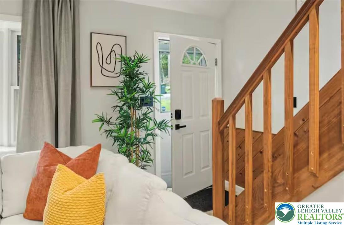 Image 4: A warm wooden staircase ascends from the welcoming
