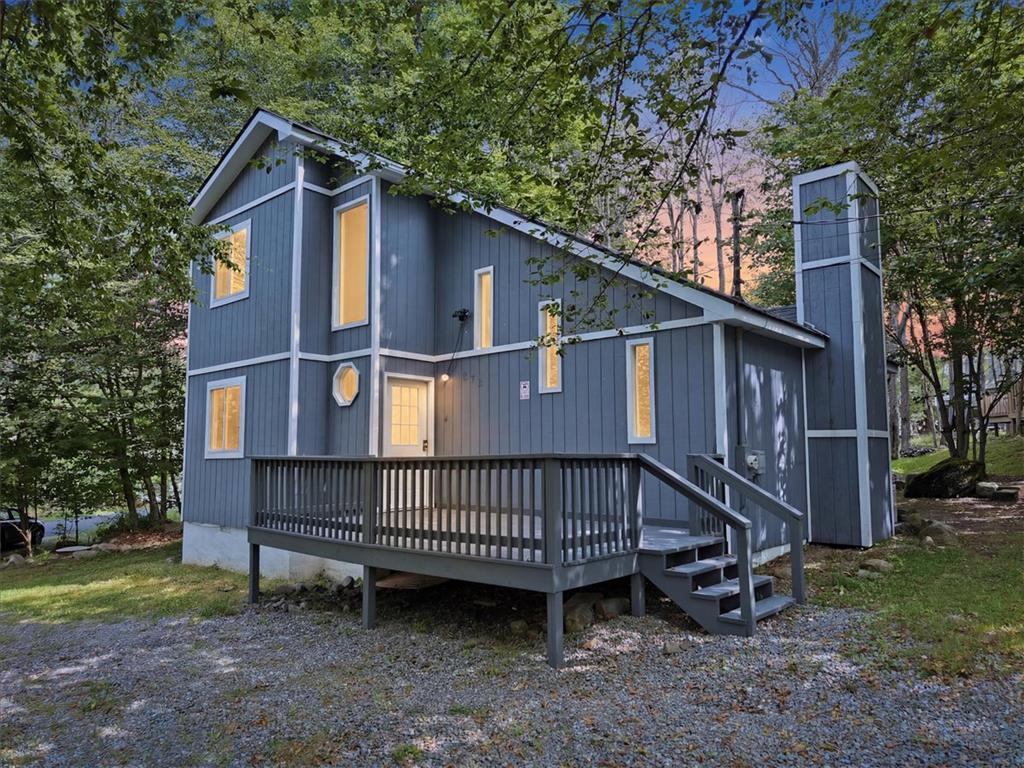 Image 1: Perched among the trees, this charming home offers