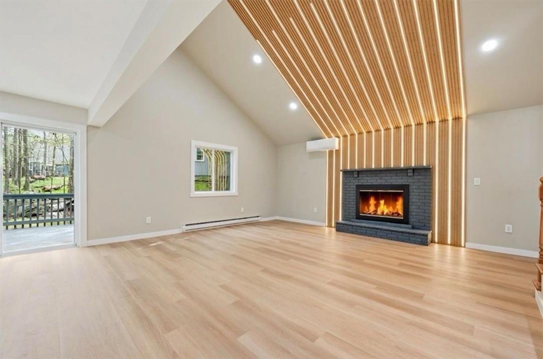 Image 3: A striking fireplace and slatted wood accent wall