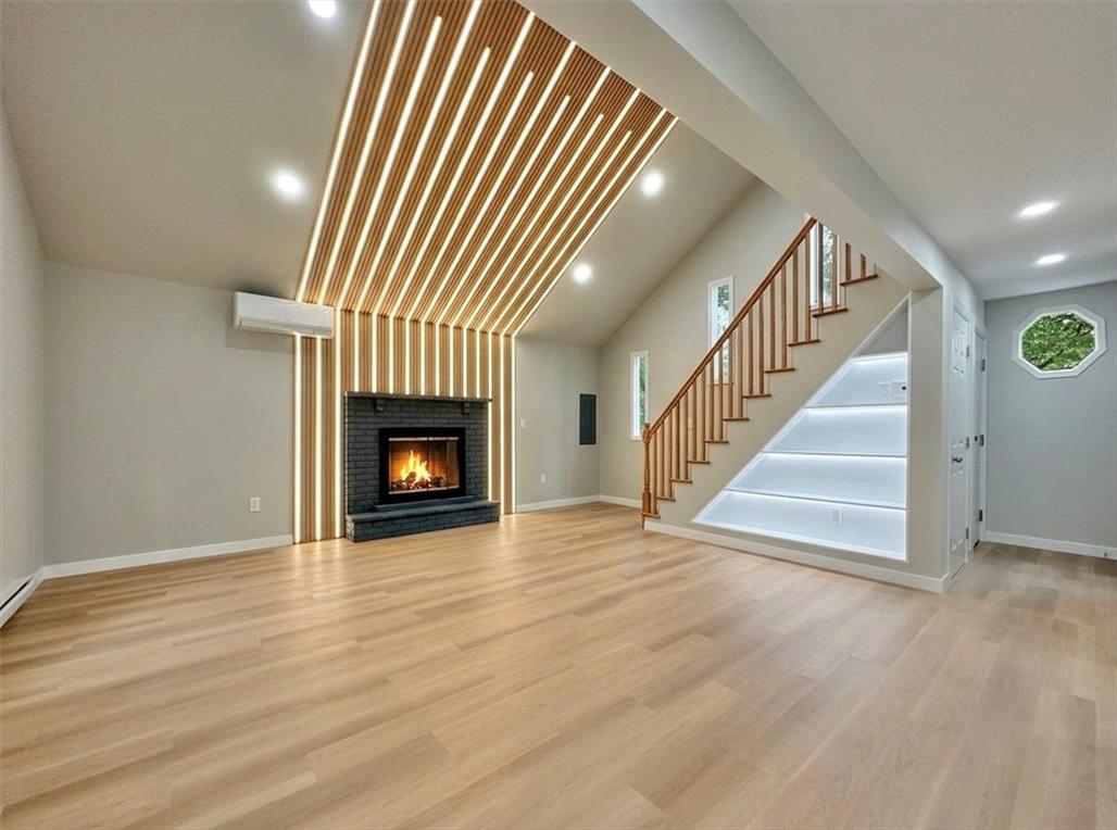 Image 4: A striking fireplace and illuminated staircase def