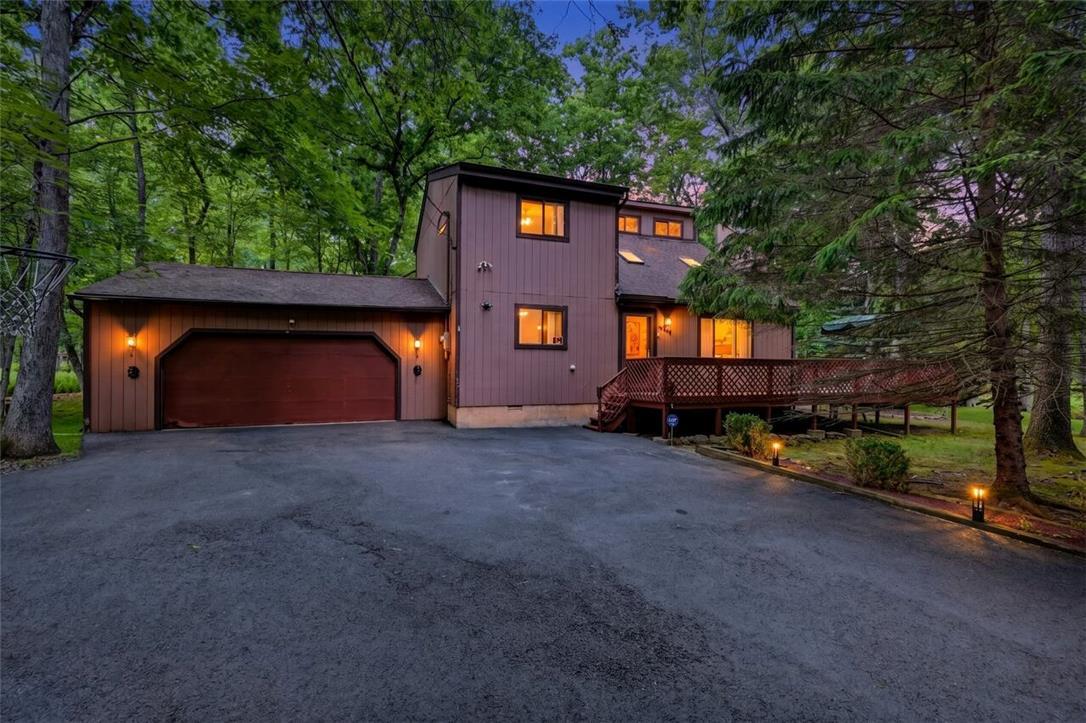 Image 1: A private wooded setting surrounds this charming h