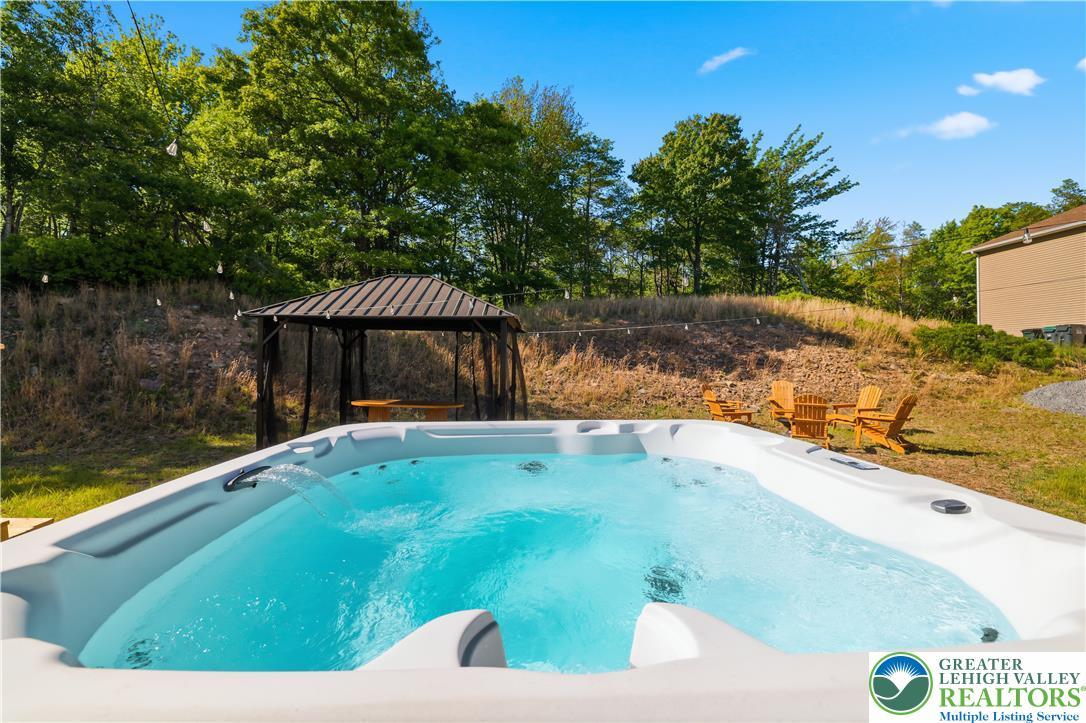 Image 2: A sparkling outdoor spa beckons, framed by a charm