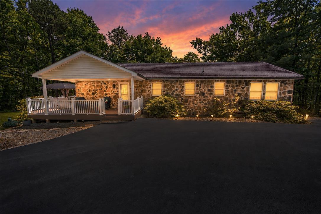Image 1: Stone facade home with a inviting covered deck, su