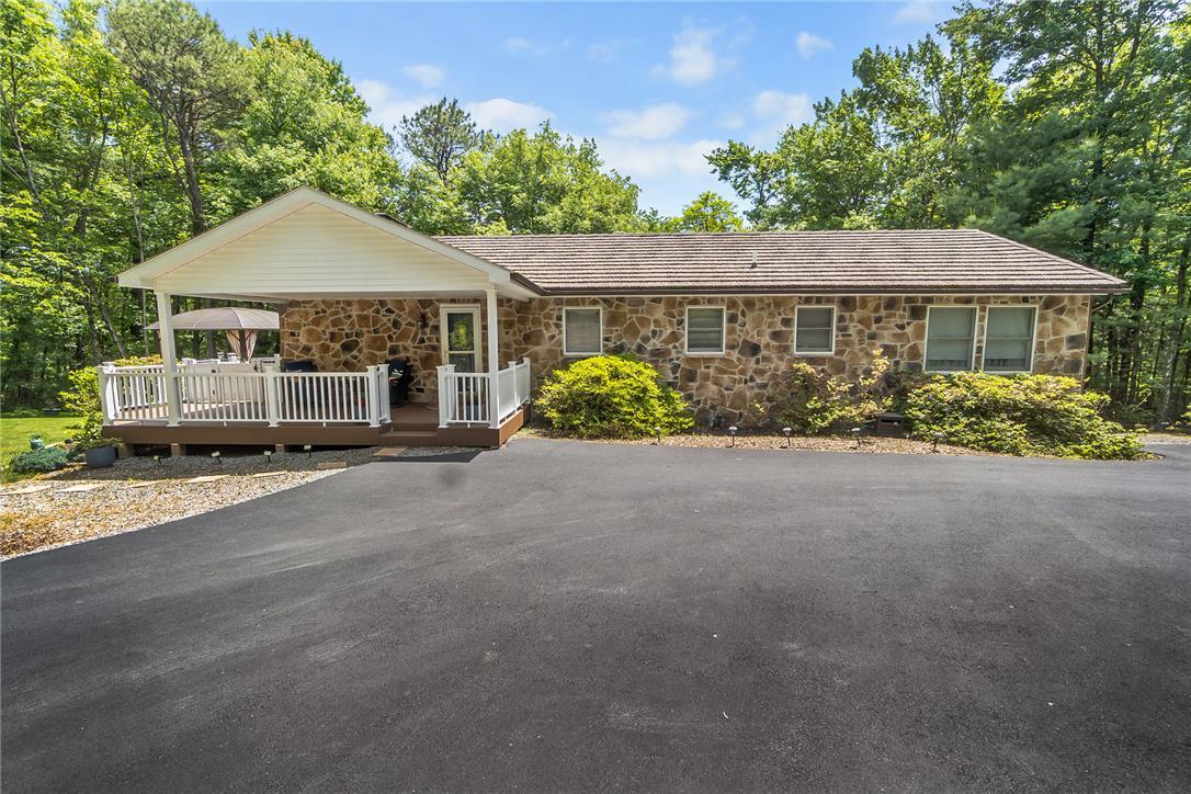 Image 2: An inviting stone-faced home with a covered porch