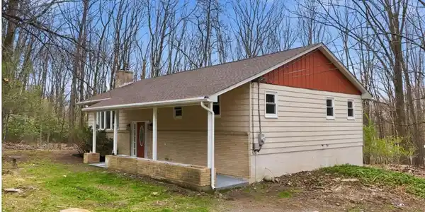 Image 3: A welcoming front porch enhances this charming res