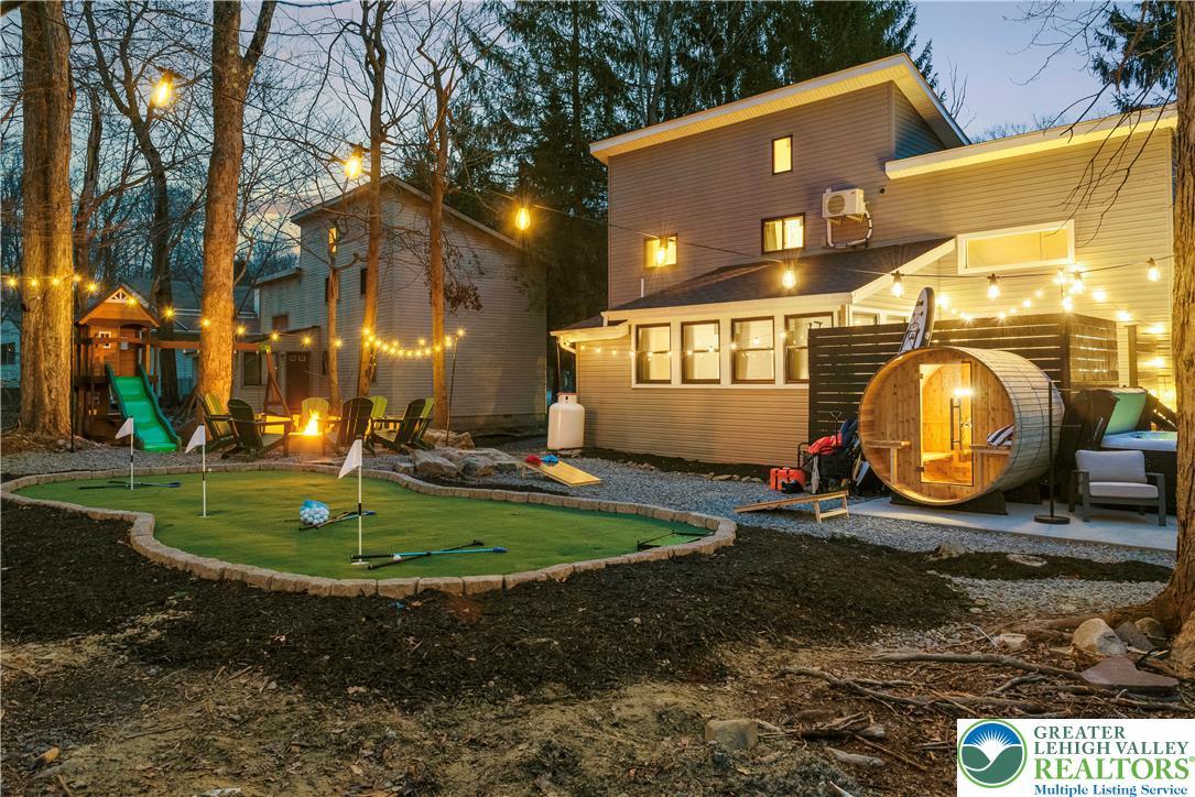 Image 1: An inviting backyard oasis offers a private puttin