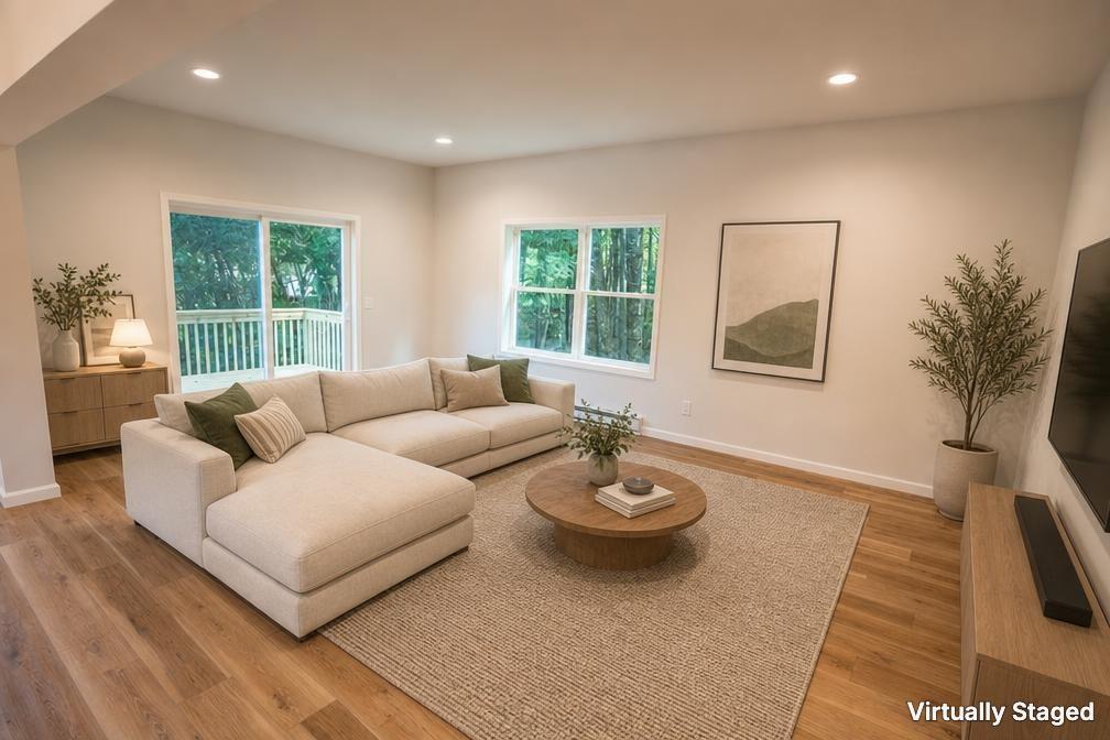 Image 3: Sun-filled living room featuring warm vinylwood fl