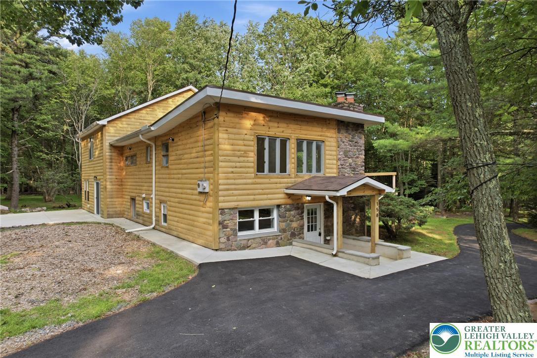 Image 3: A charming wood-sided residence, accented with nat
