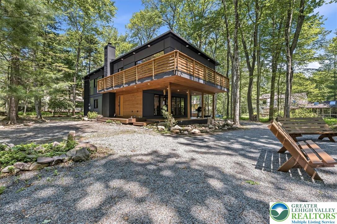 Image 3: Modern retreat nestled in a wooded setting, offeri