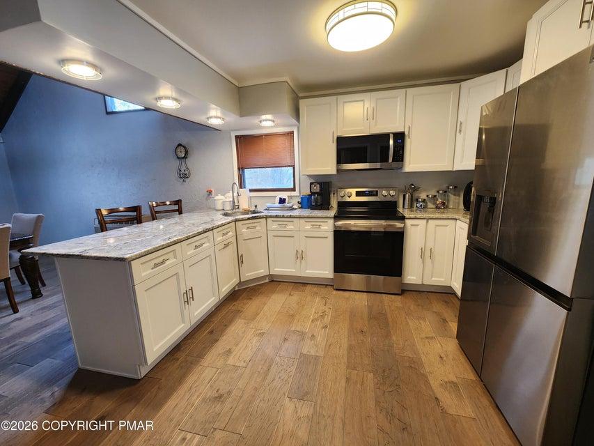 Image 2: This kitchen features a spacious layout with hardw