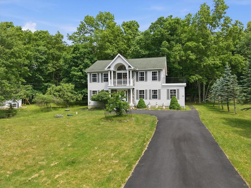 Image 3: A classic two-story home, nestled among lush green