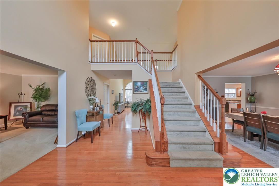 Image 4: Grand foyer with gleaming wood floors and a sweepi