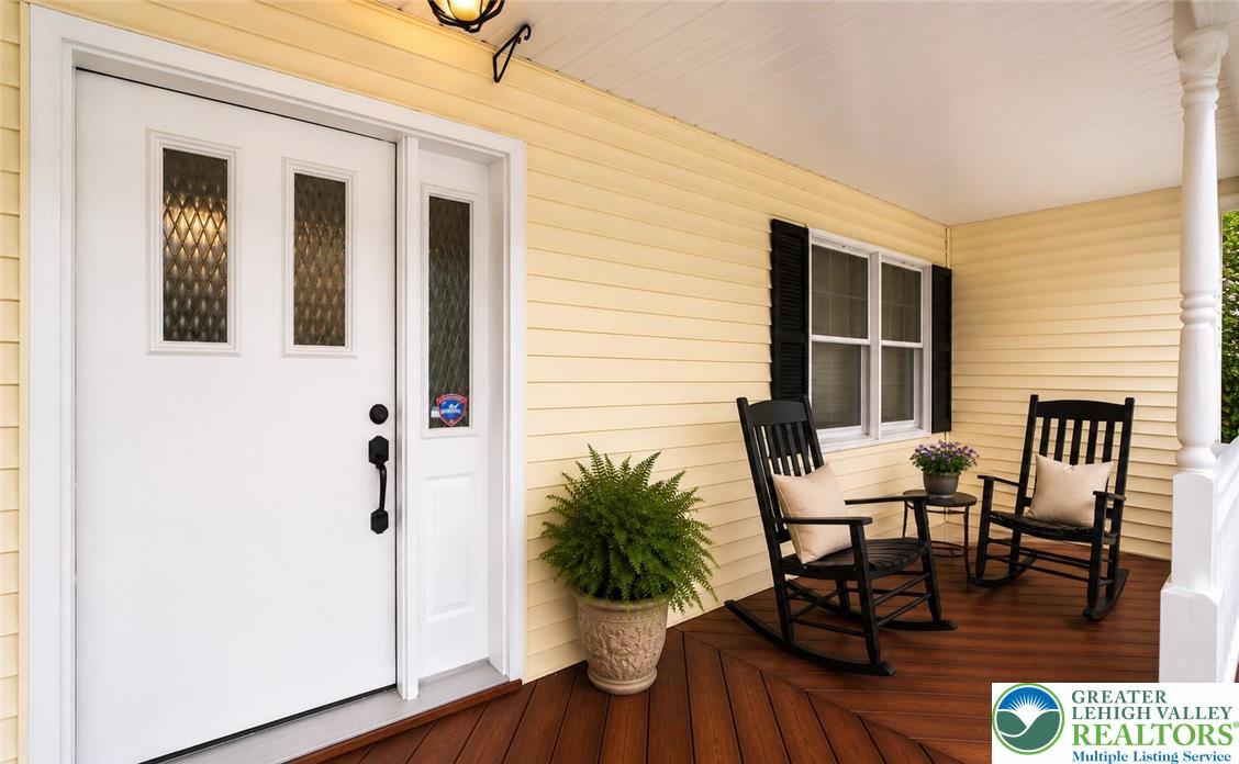 Image 3: A welcoming wooden porch invites relaxation with c