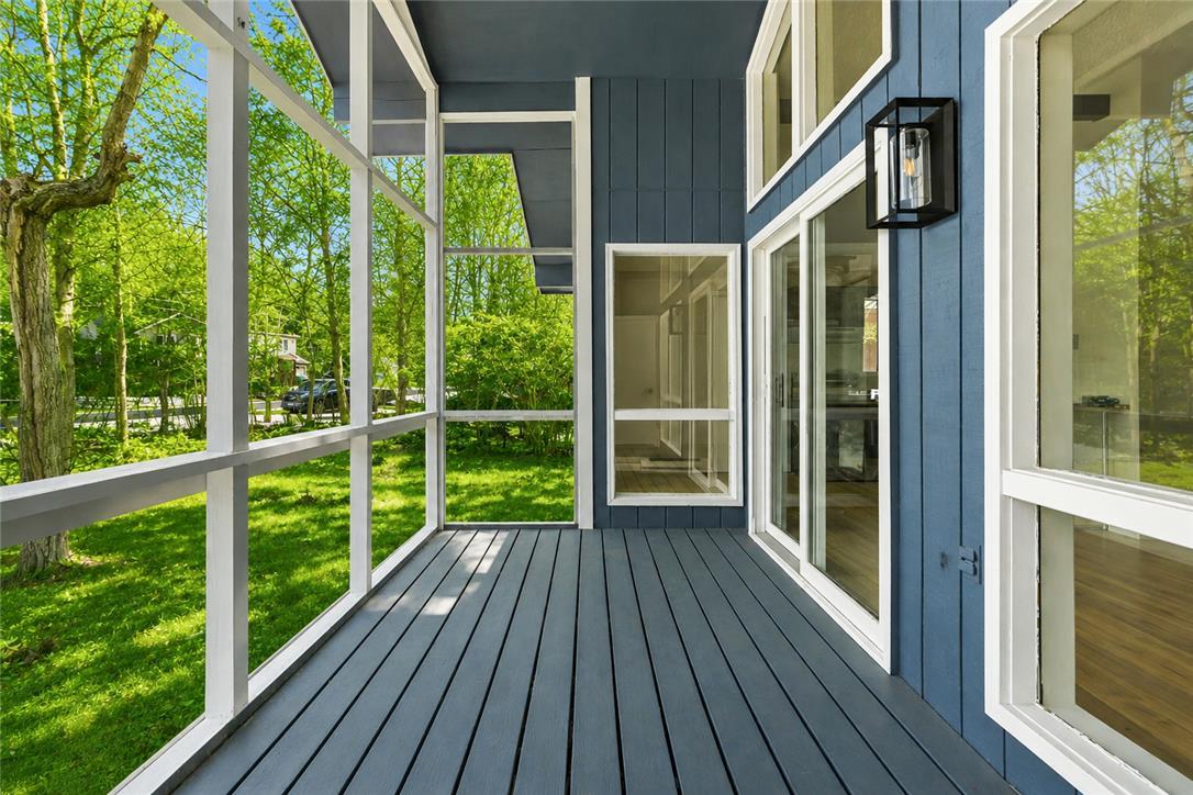 Image 2: A well-lit screened porch offers tranquil views of