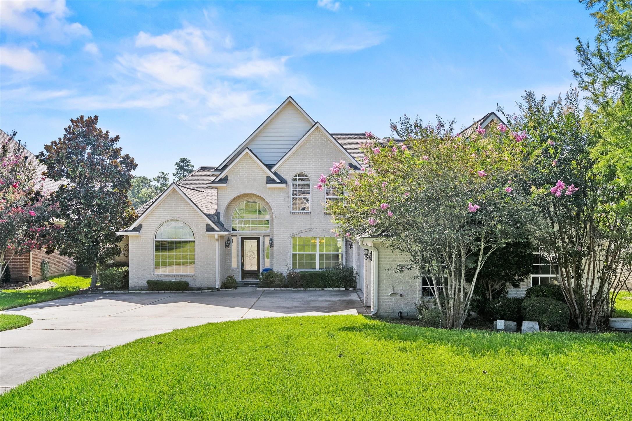 Image 3: This charming two-story home features a light bric