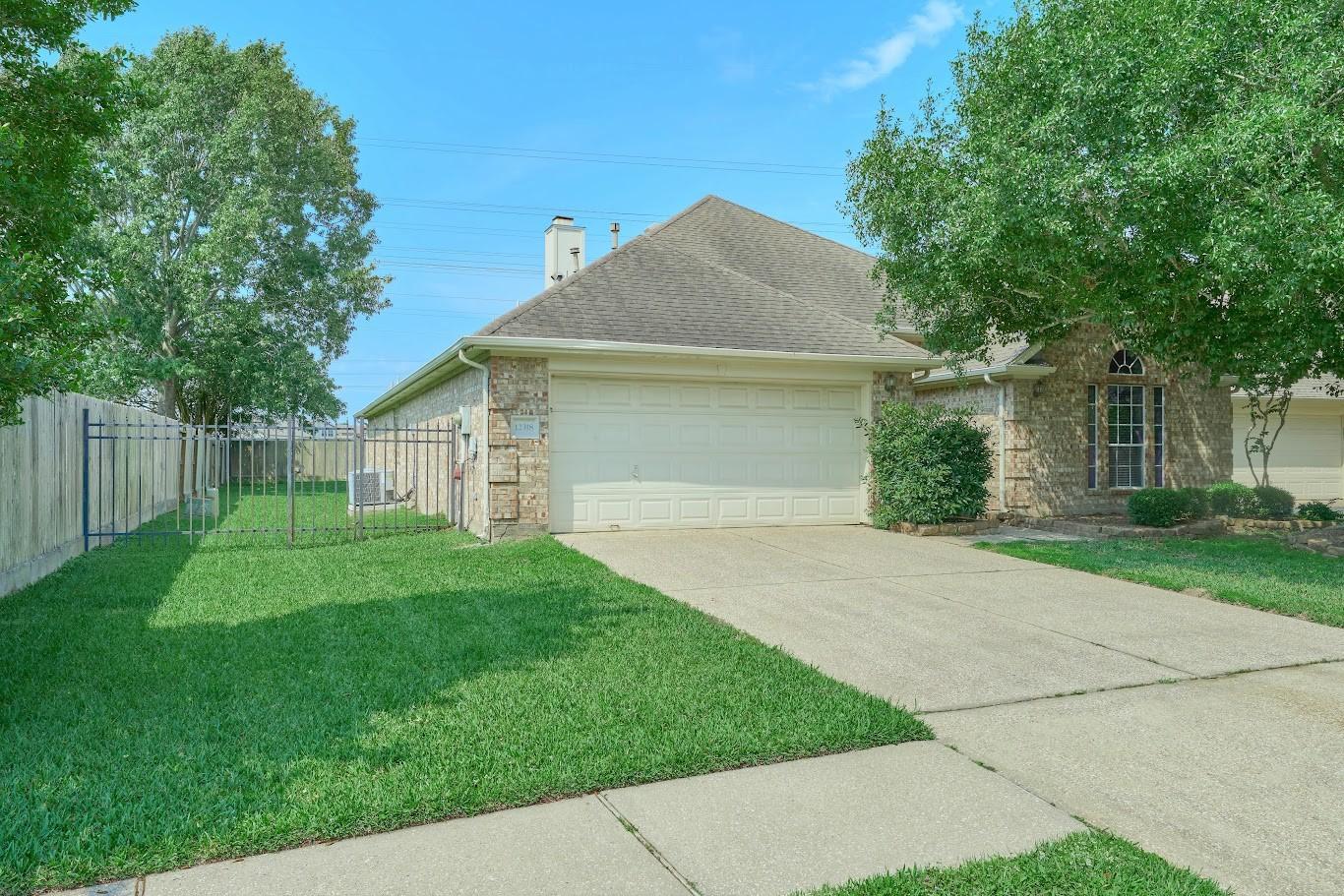 Image 2: Large side yard with iron fence and gated entryway