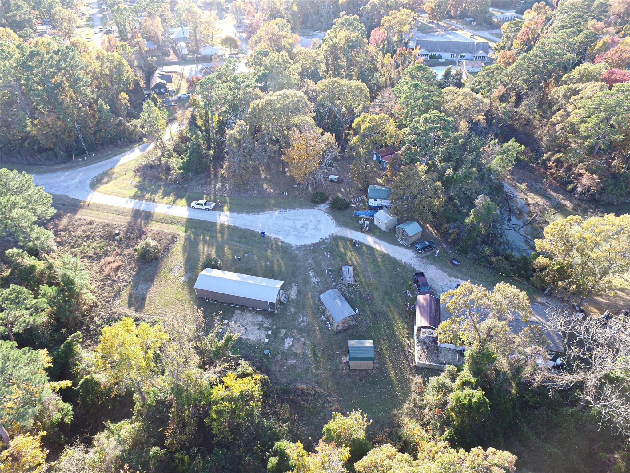 Image 4: This aerial photo shows a spacious, wooded propert