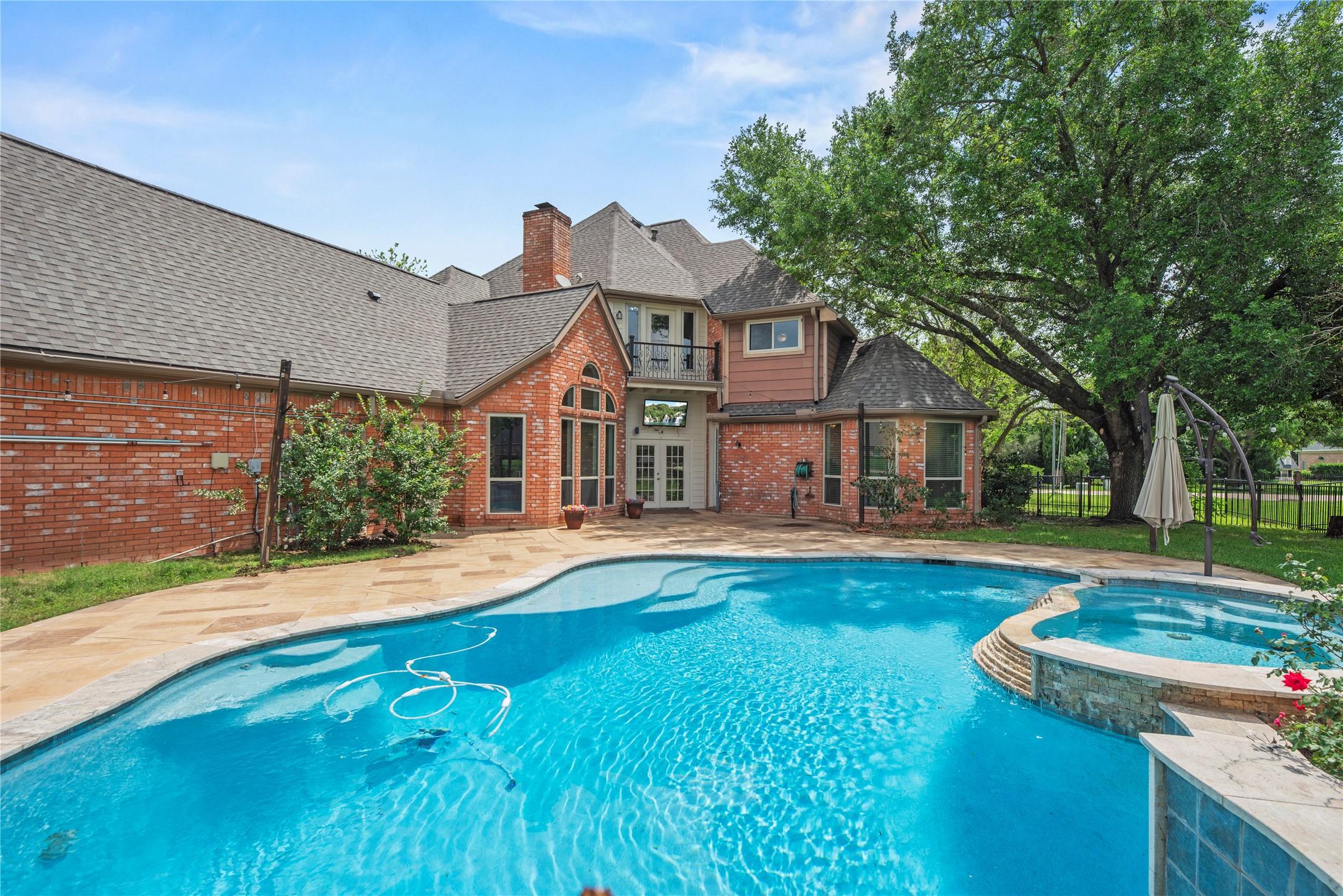 Image 1: Resort-style backyard with heated pool & spa overl