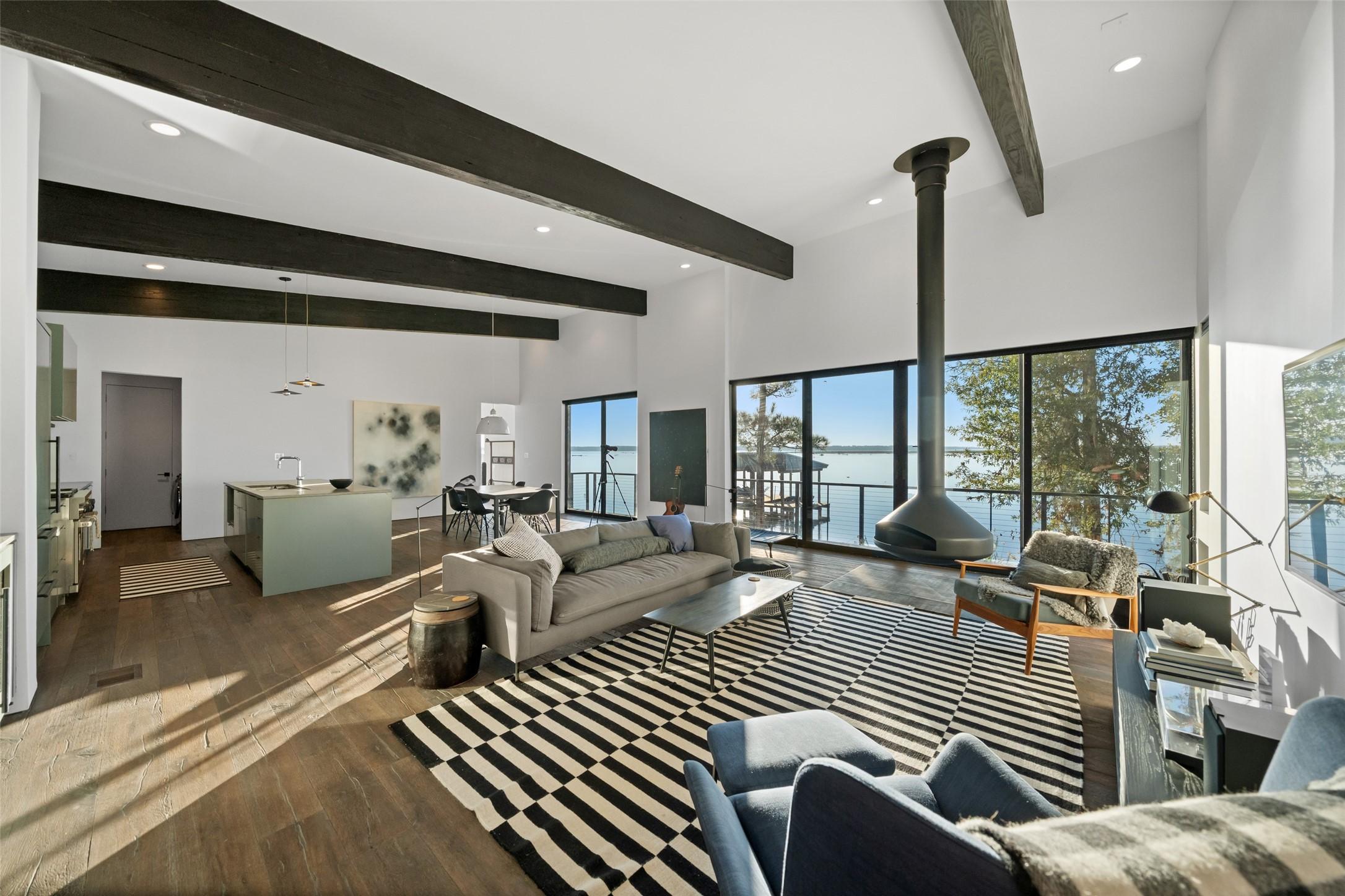 Image 3: Vaulted, beam-accented living space anchored by a